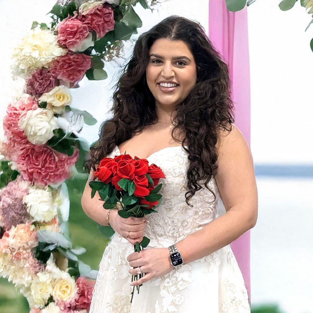 woman holding leather wedding bouquet under flower arch